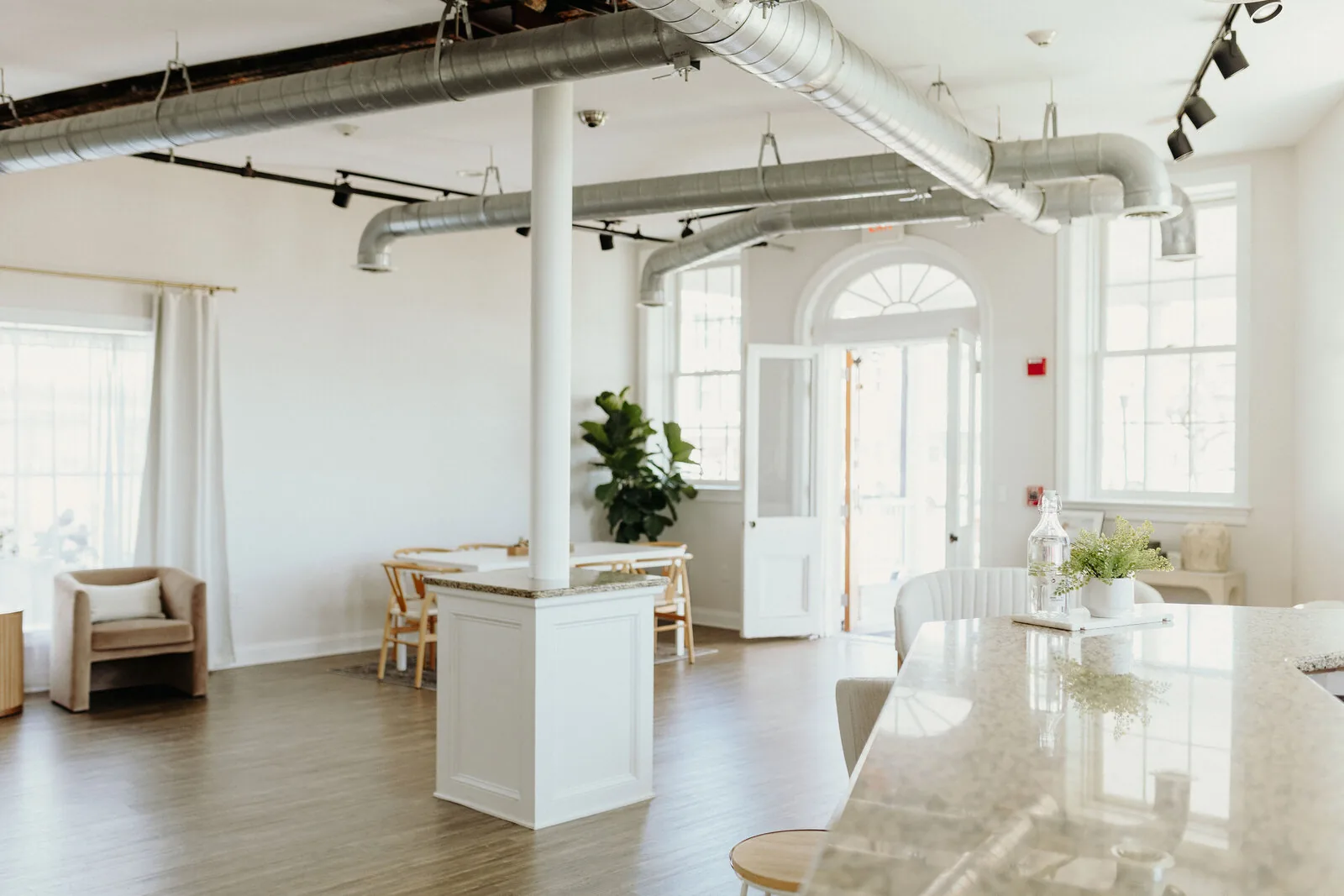 Inside Petit Social Studio in Delaware City, a light-filled waterfront event space and photo studio with a historic arched entrance